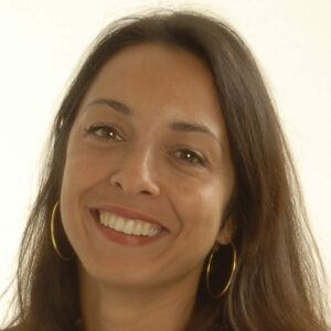 A smiling woman with long hair and hoop earrings.