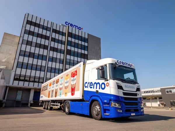 A blue and white truck parked in front of a building.