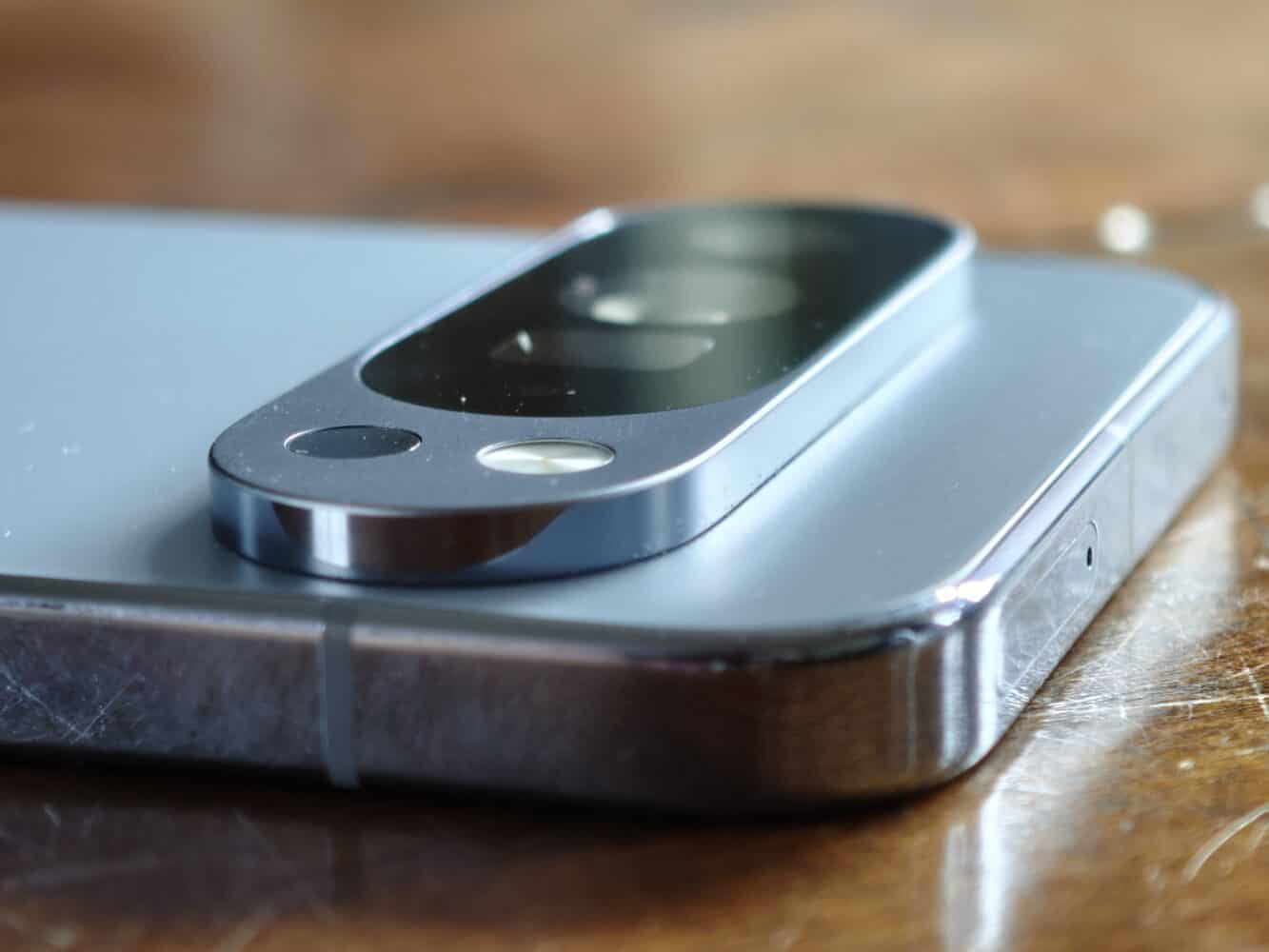 Close-up of a smartphone’s rear camera module, showing the lens and flash on a reflective metal surface.